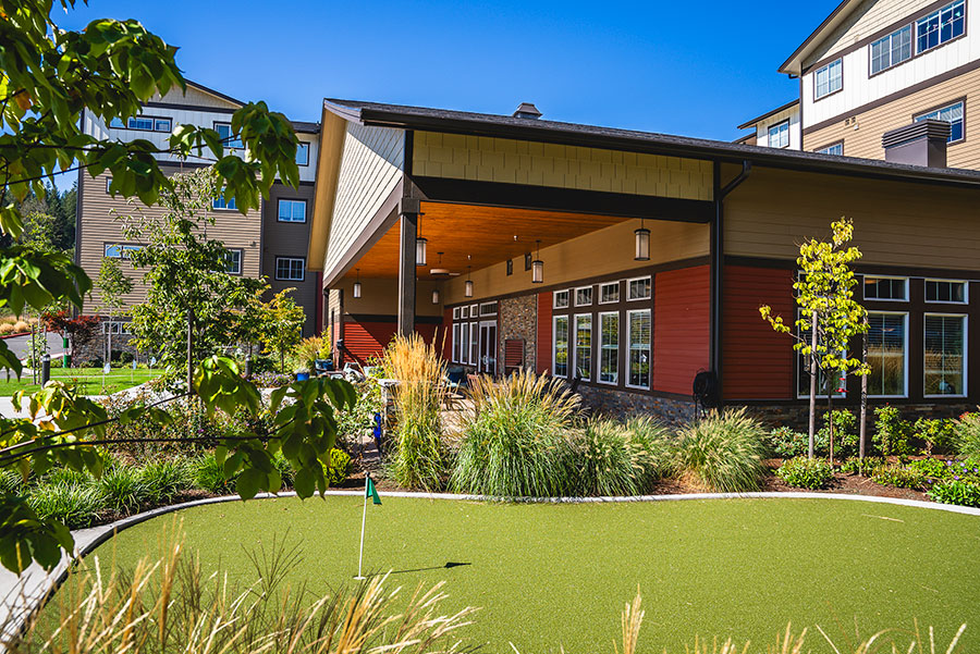 Exterior of a colorful building with lush landscaping.
