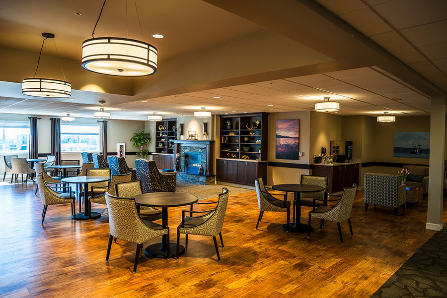 Comfortable lounge with tables, chairs, and natural light.