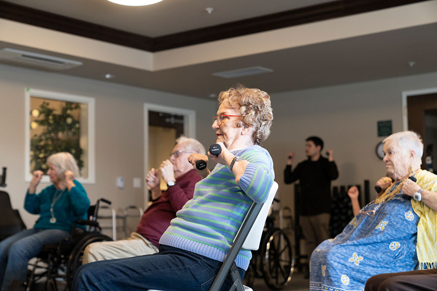 Seniors participating in an exercise class with weights.
